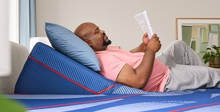 A man laying on a Posturepedic Elite mattress