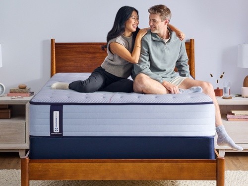 Couple sitting on a Posturepedic Spring mattress