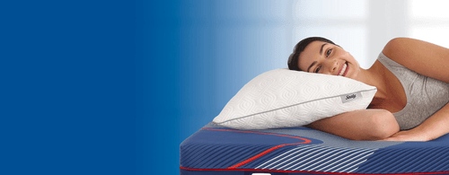 Woman laying on a Sealy adjustable pillow with blue gradient background