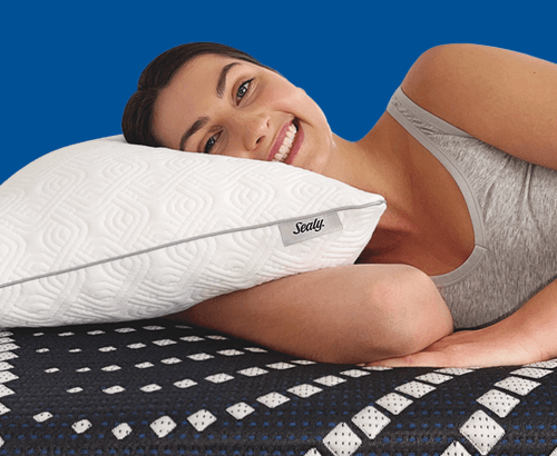 A woman laying on a Sealy adjustable pillow with blue background