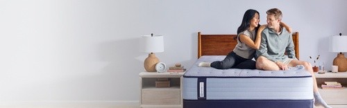 a couple sitting on a posturepedic spring