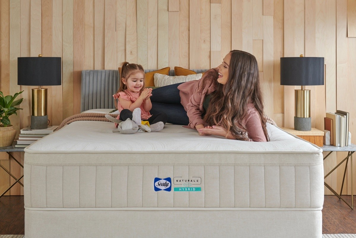 Woman and child laying on a mattress laughing