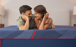 A couple laying on a Posturepedic Elite Hybrid mattress