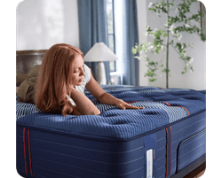 A woman laying on a Posturepedic Elite Spring mattress
