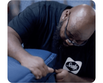 A man inspecting a Sealy mattress